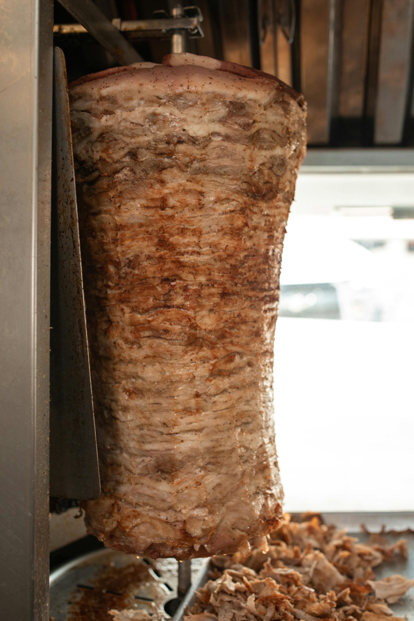Close-up of shawarma meat cooking on a vertical rotisserie, ready to be served.